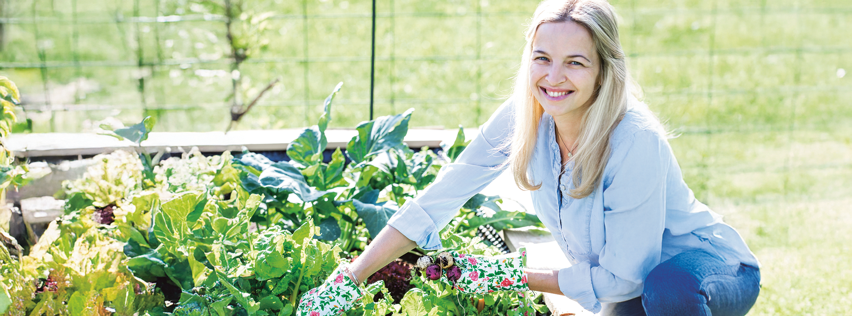 Frau bepflanzt Hochbeet