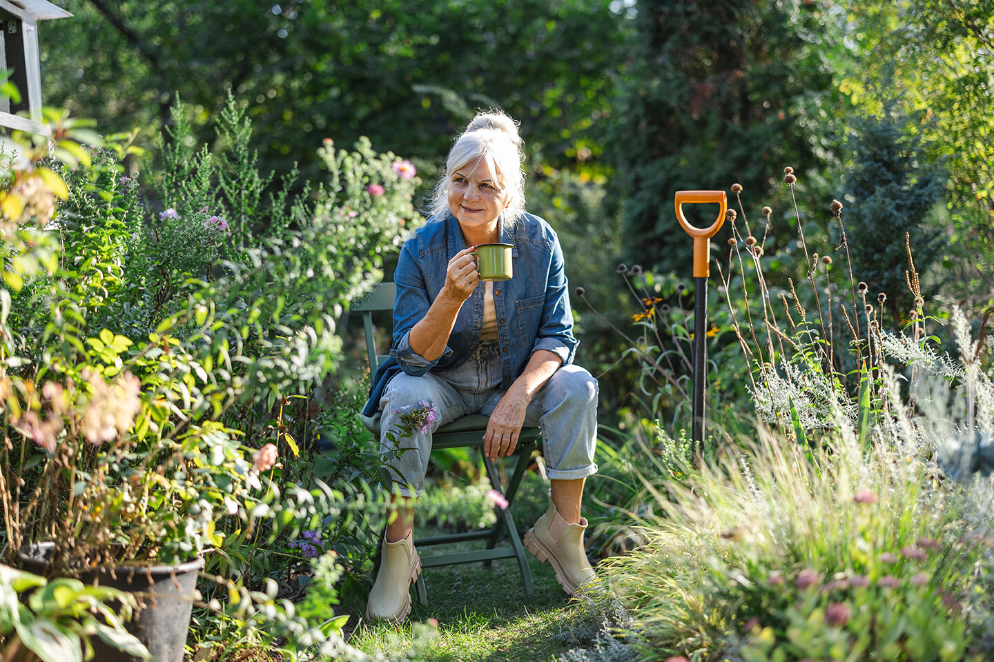 Frau trinkt Kaffee im Garten